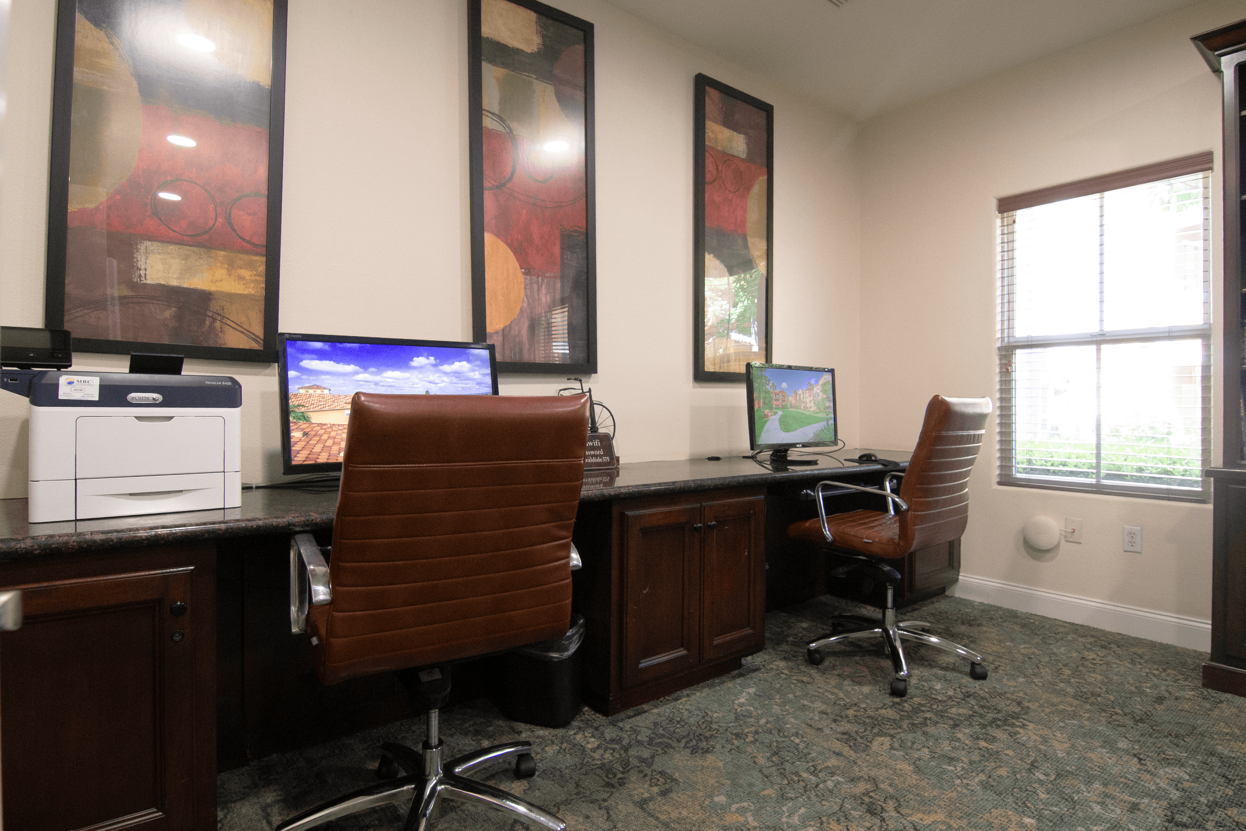 A room with two chairs and two computers.