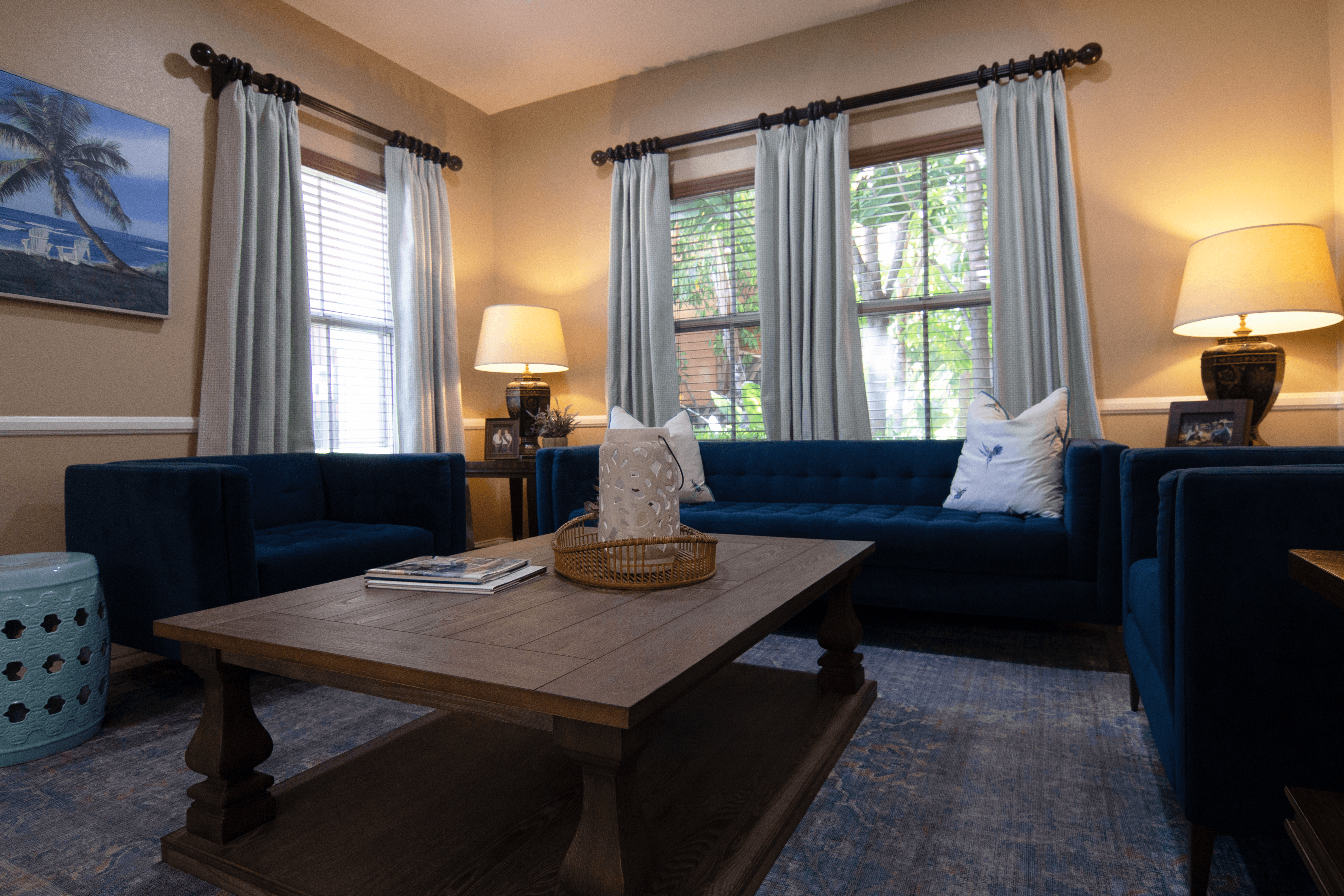 A living room with blue couches and a wooden coffee table.