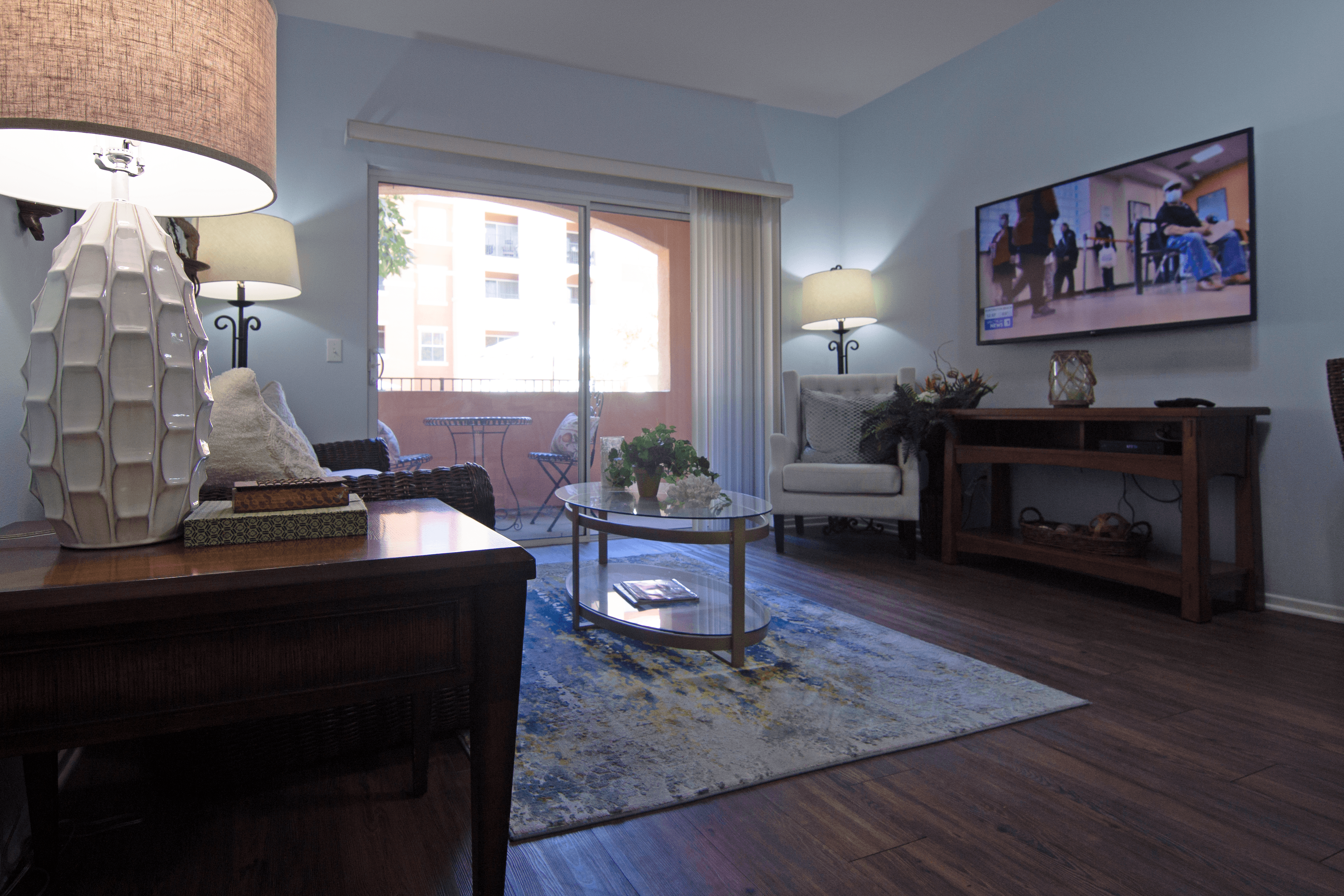 A living room with a sofa, a coffee table, a lamp, and a television.