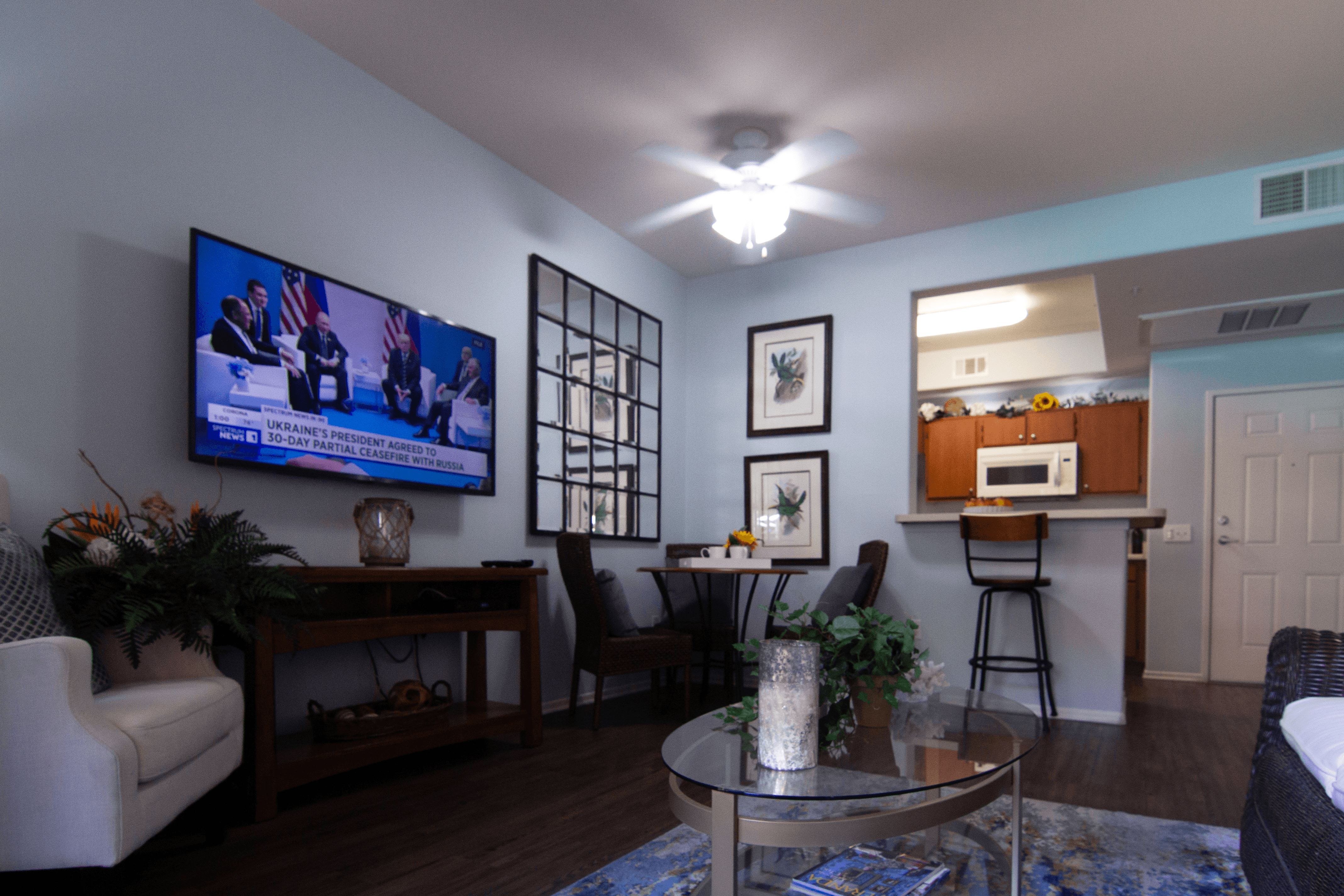 A living room with a television on the wall and a couch.