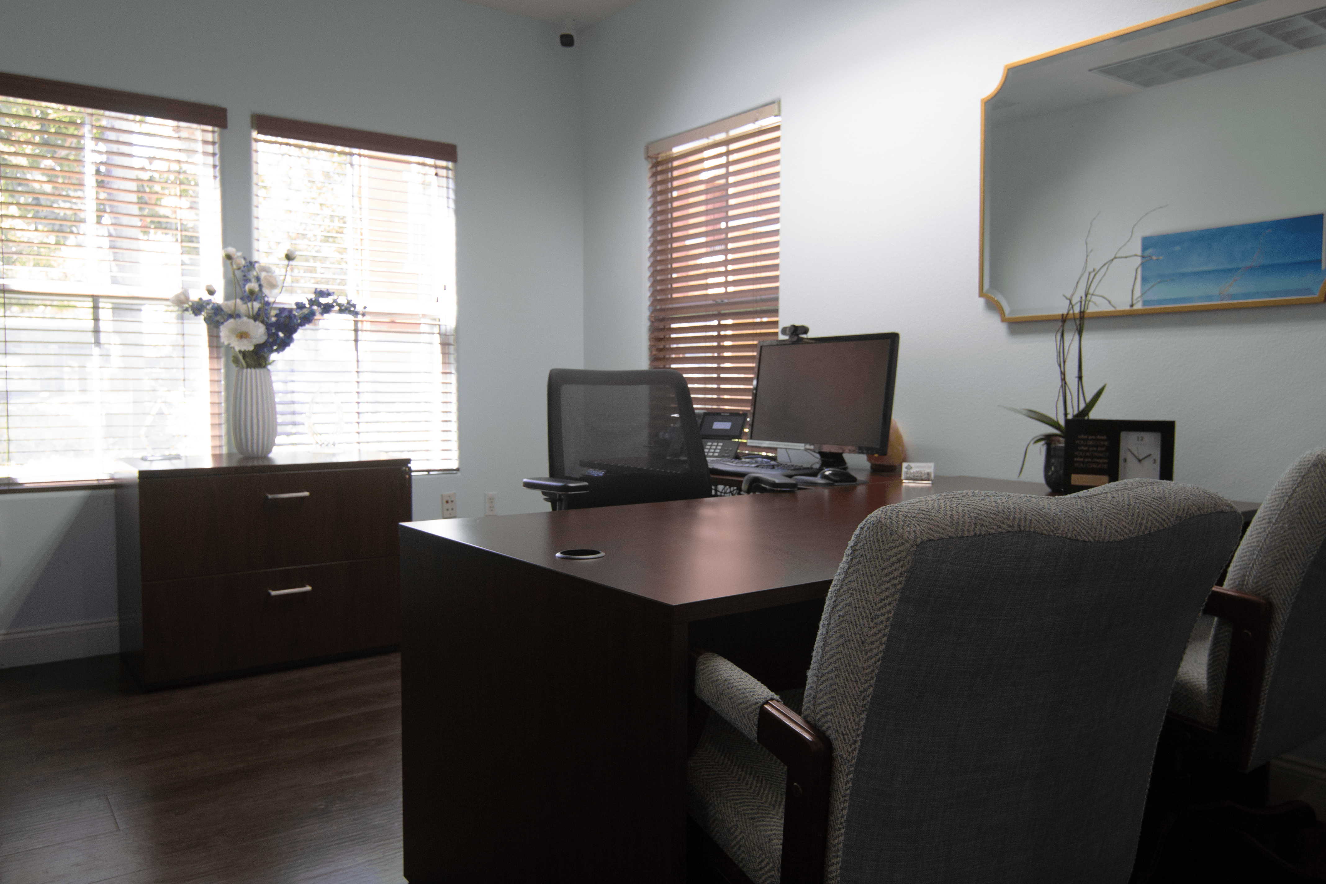 A room with a desk, chairs, and a laptop.,A room with a desk, chairs, and a laptop.