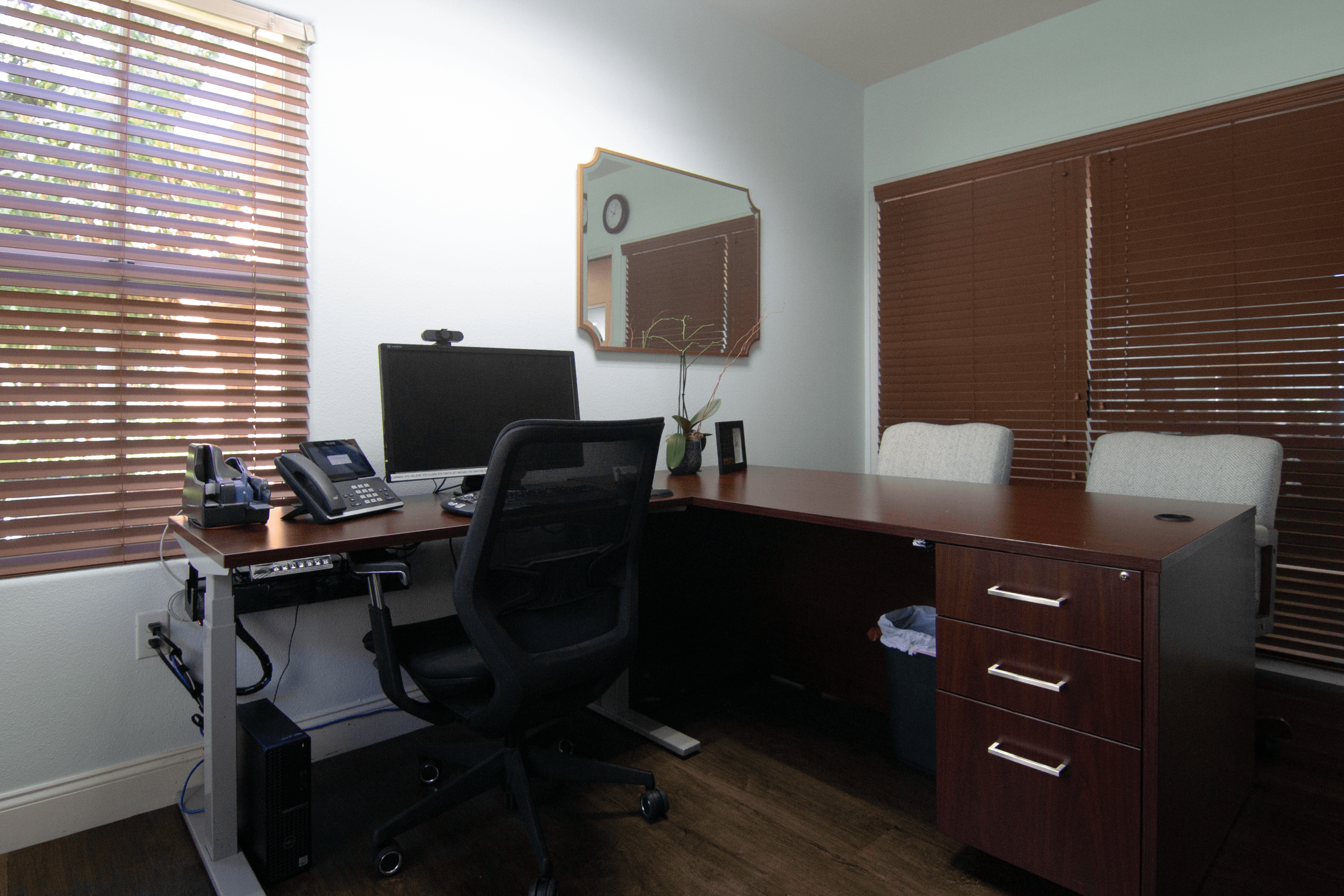 A black office chair is in front of a desk with a computer monitor, keyboard, and mouse.,A black office chair is in front of a desk with a computer monitor, keyboard, and mouse.
