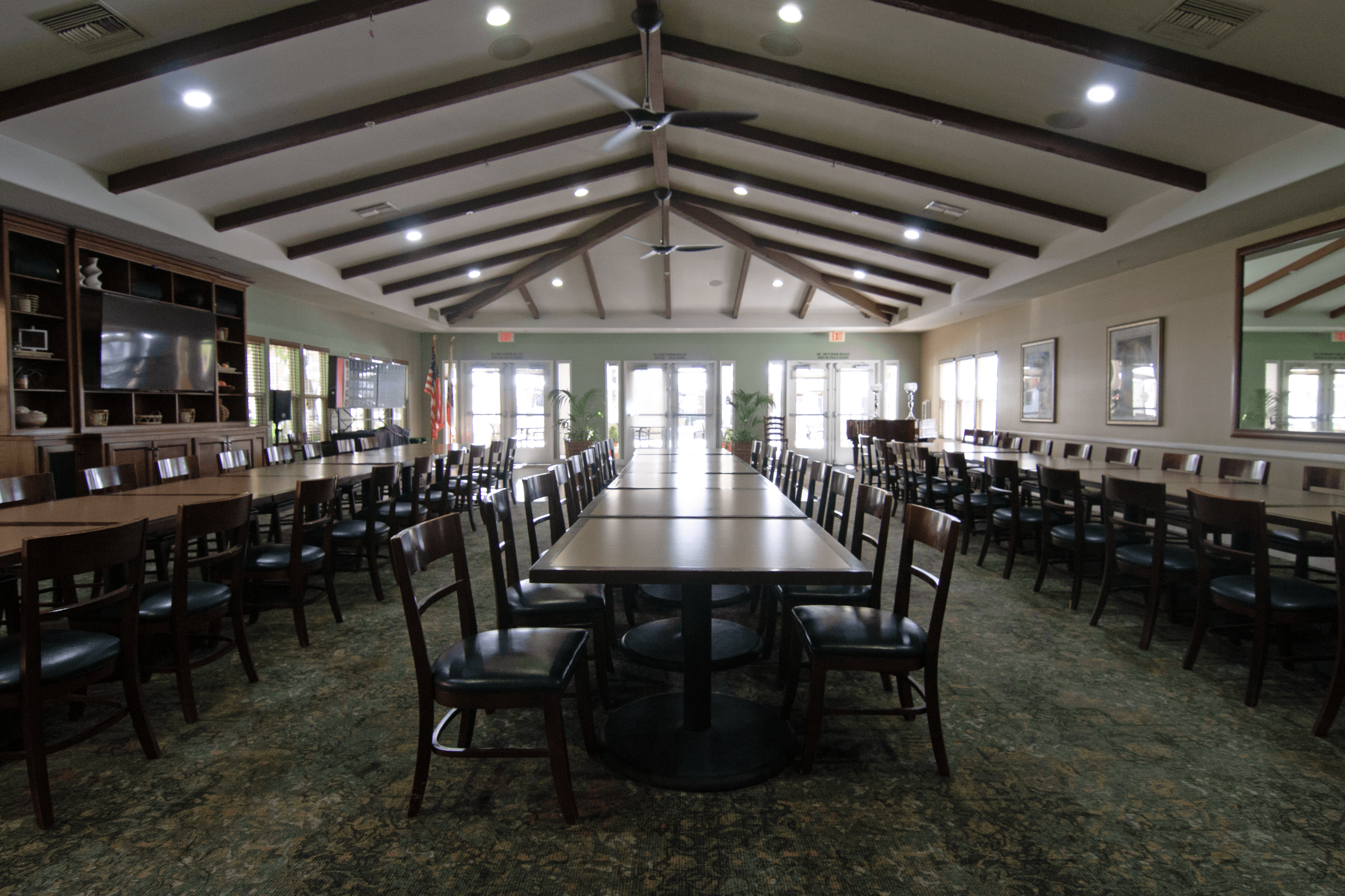 A large room with tables and chairs.,A large room with tables and chairs.