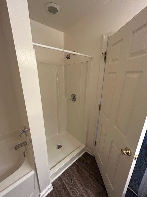 A white bathroom with a door and a shower.