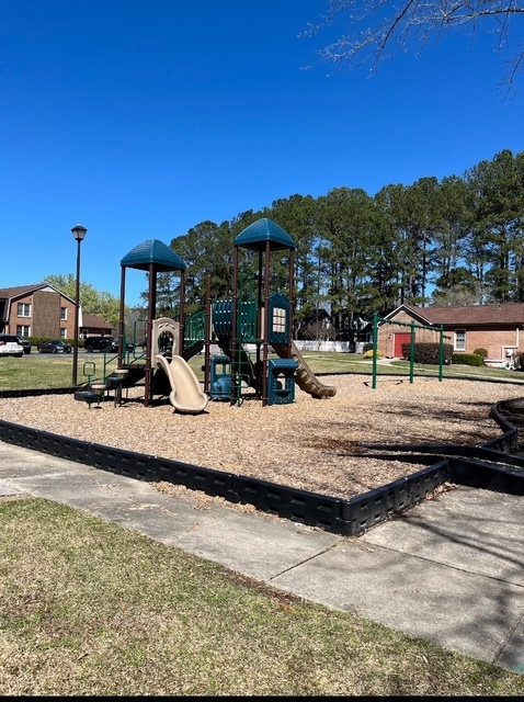 A playground with a slide and a swing set.