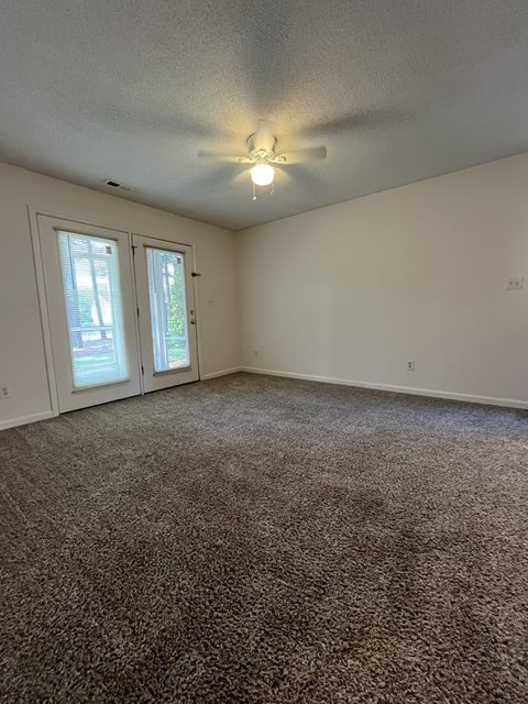 A room with a carpeted floor and a ceiling light.