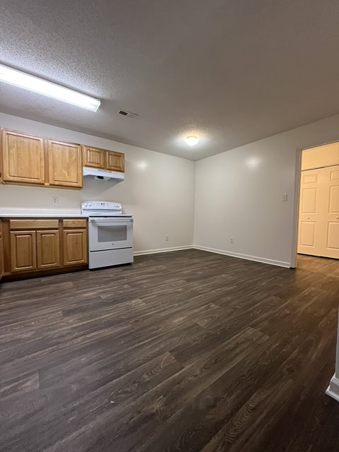 A kitchen with wooden cabinets and a white dishwasher.