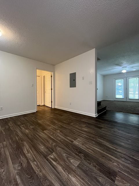 A room with wood flooring and white walls.