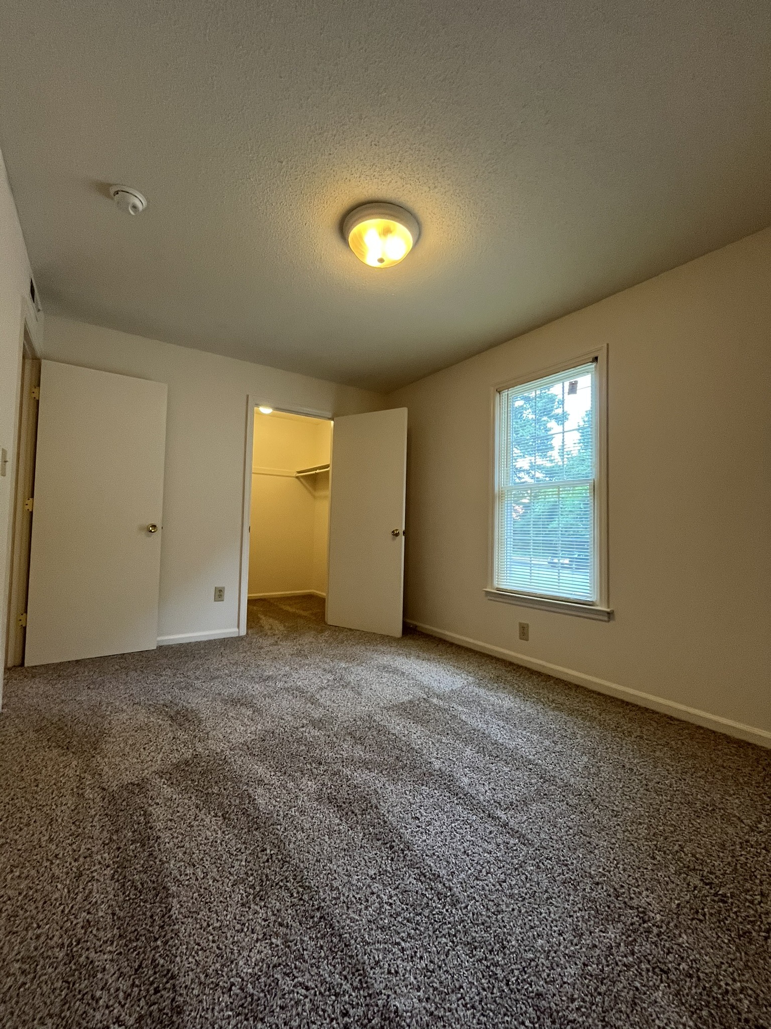 A room with a carpeted floor and a window.,A room with a carpeted floor and a window.