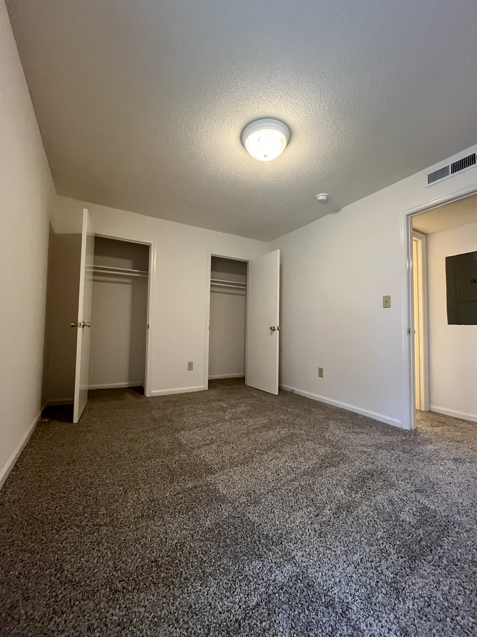 A room with a carpeted floor and a ceiling light.,A room with a carpeted floor and a ceiling light.