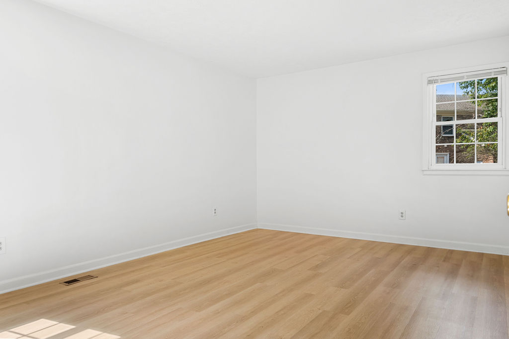 Empty room with wooden floor and white walls.