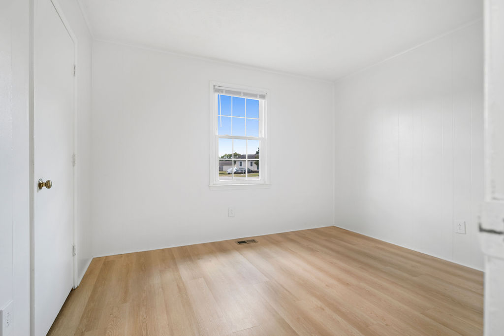 Empty room with wooden floor and a window.
