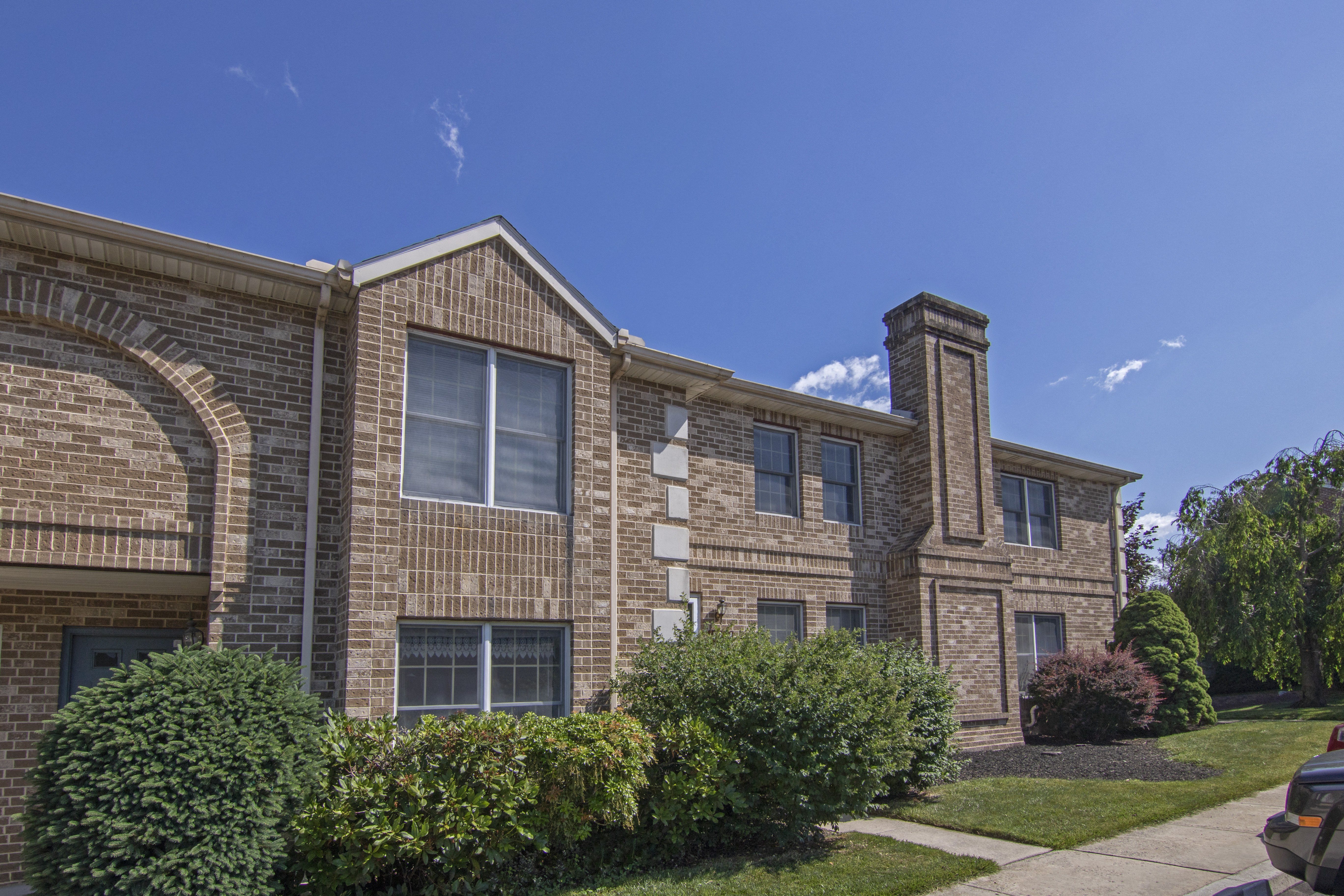 A large house with a brick facade and a chimney.