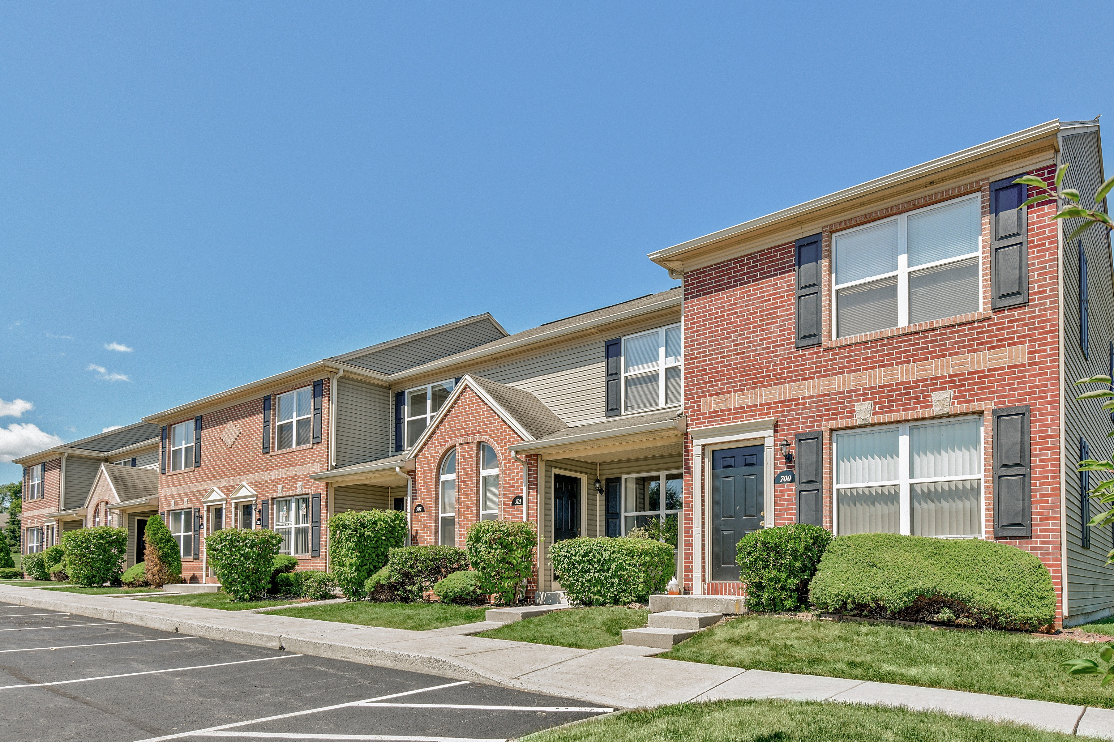 A row of townhouses with a clear blue sky above them.