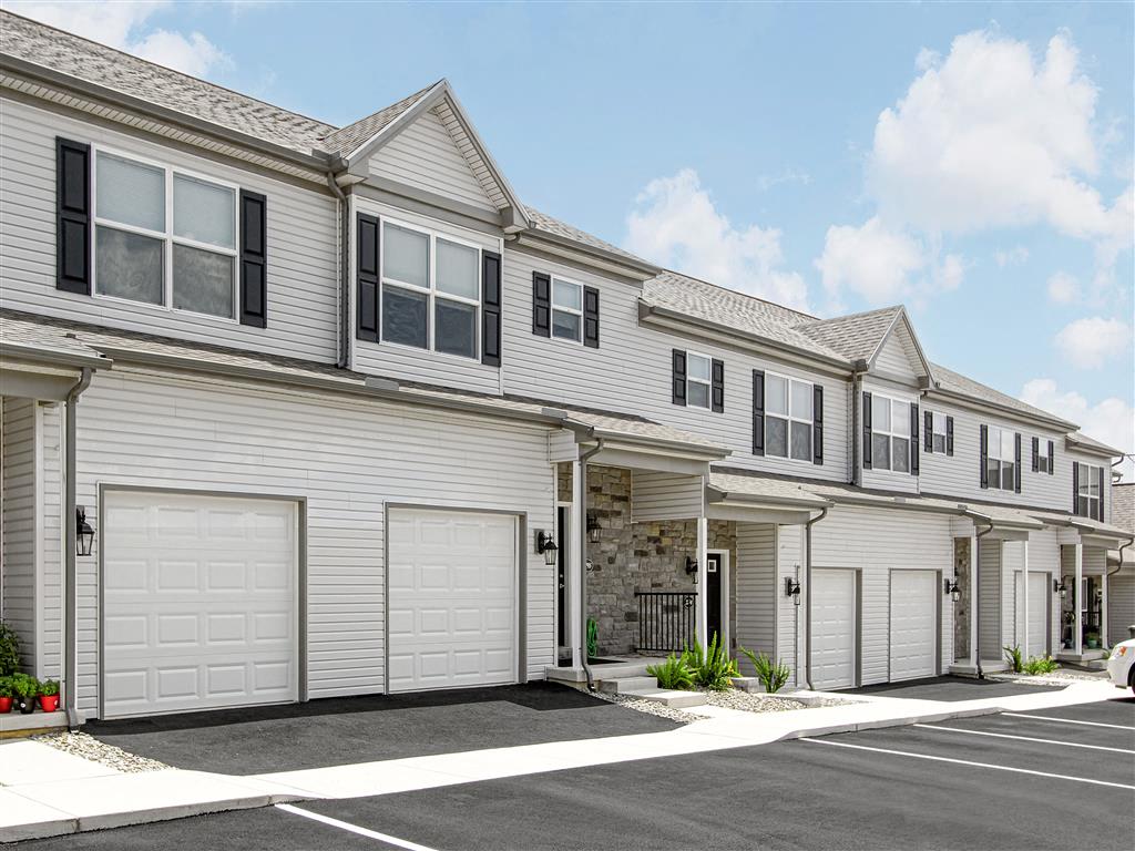 A row of townhouses with garages and a clear sky.