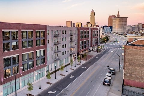 View of exterior of Quarter apartment building, Detroit avenue and downtown Cleveland at sunset