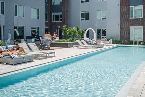 Pool surrounded by residents in lounge chairs