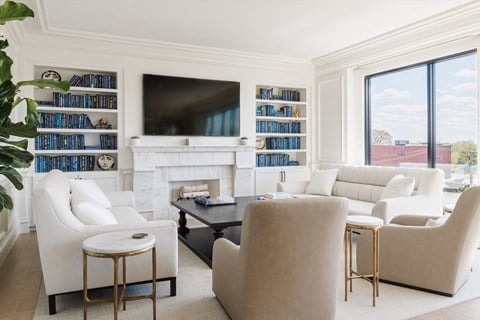 Lounge with built-in bookshelves, mounted television, soft seating and view of city out windows