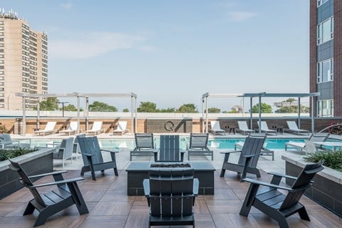 Pool deck with groupings of adirondack chairs and a fire pit