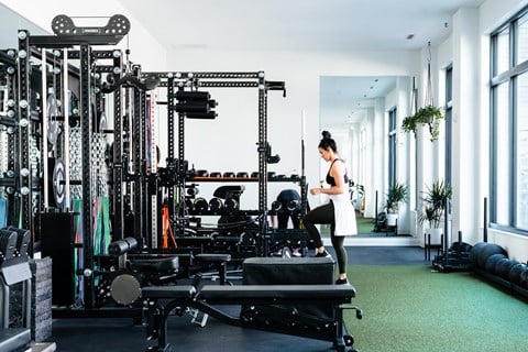Woman exercising in The Mill gym, surrounded by equipment