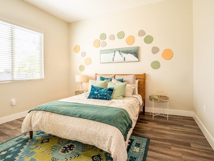 Model bedroom is furnished with a large bed and 2 nightstands at Village Greens of Queen Creek