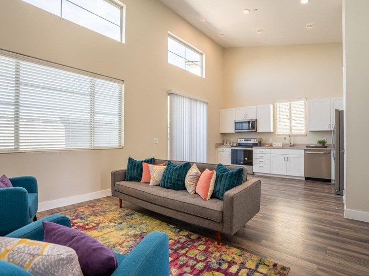 Furnished open floor plan living area has a couch and chairs in an apartment at Village Green of Queen Creek