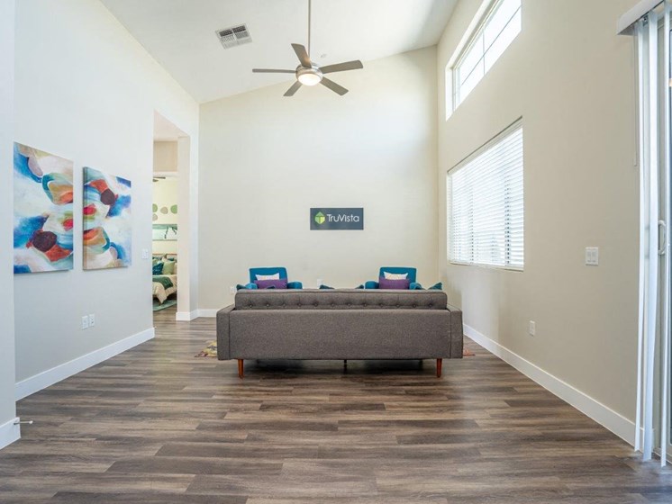 Wood-style flooring in a living room furnished with a couch at Village Greens of Queen Creek