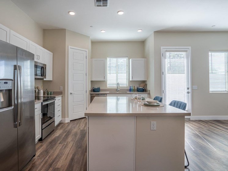 Open floor plan shows a kitchen with a large island in an apartment at Village Greens of Queen Creek