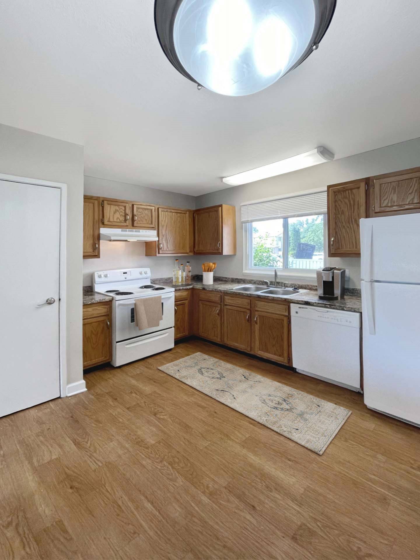 A kitchen with wooden cabinets and white appliances.