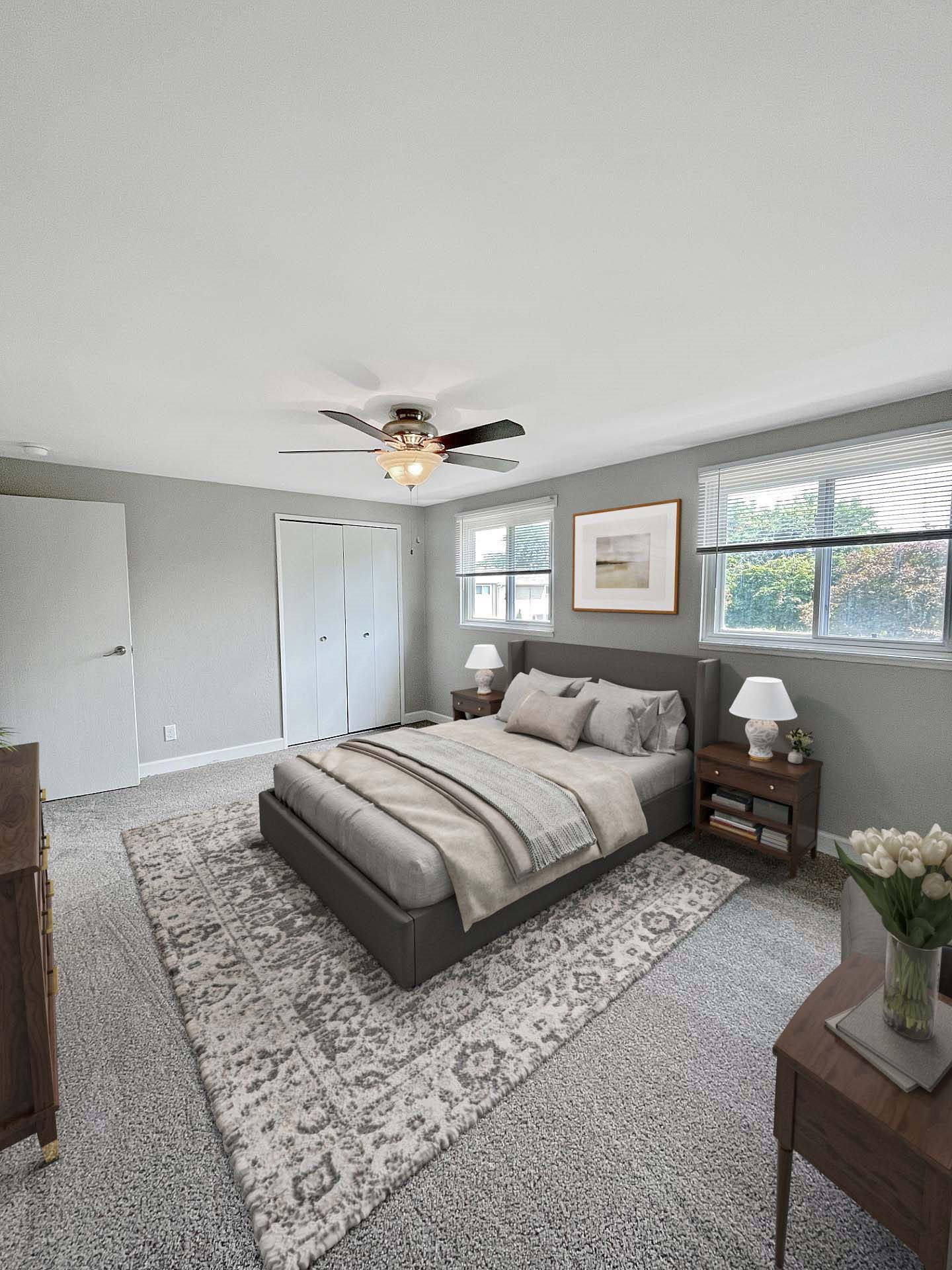 A bedroom with a bed, a ceiling fan, and a rug.