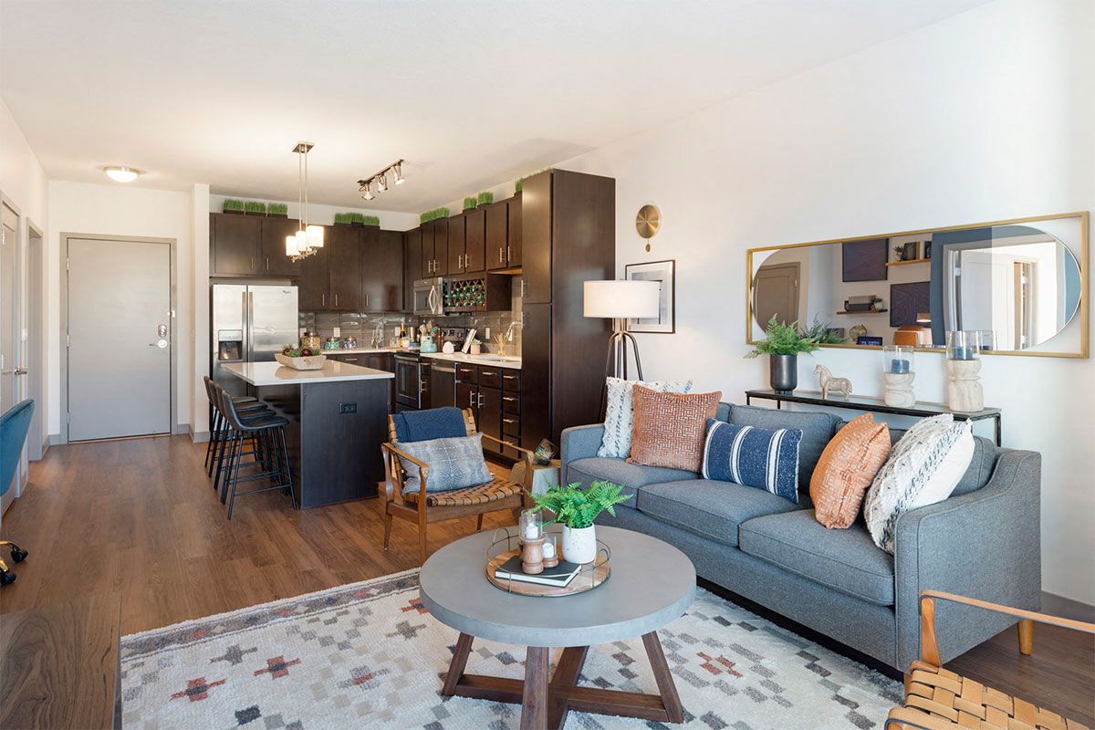 a living room and kitchen with a couch and a table