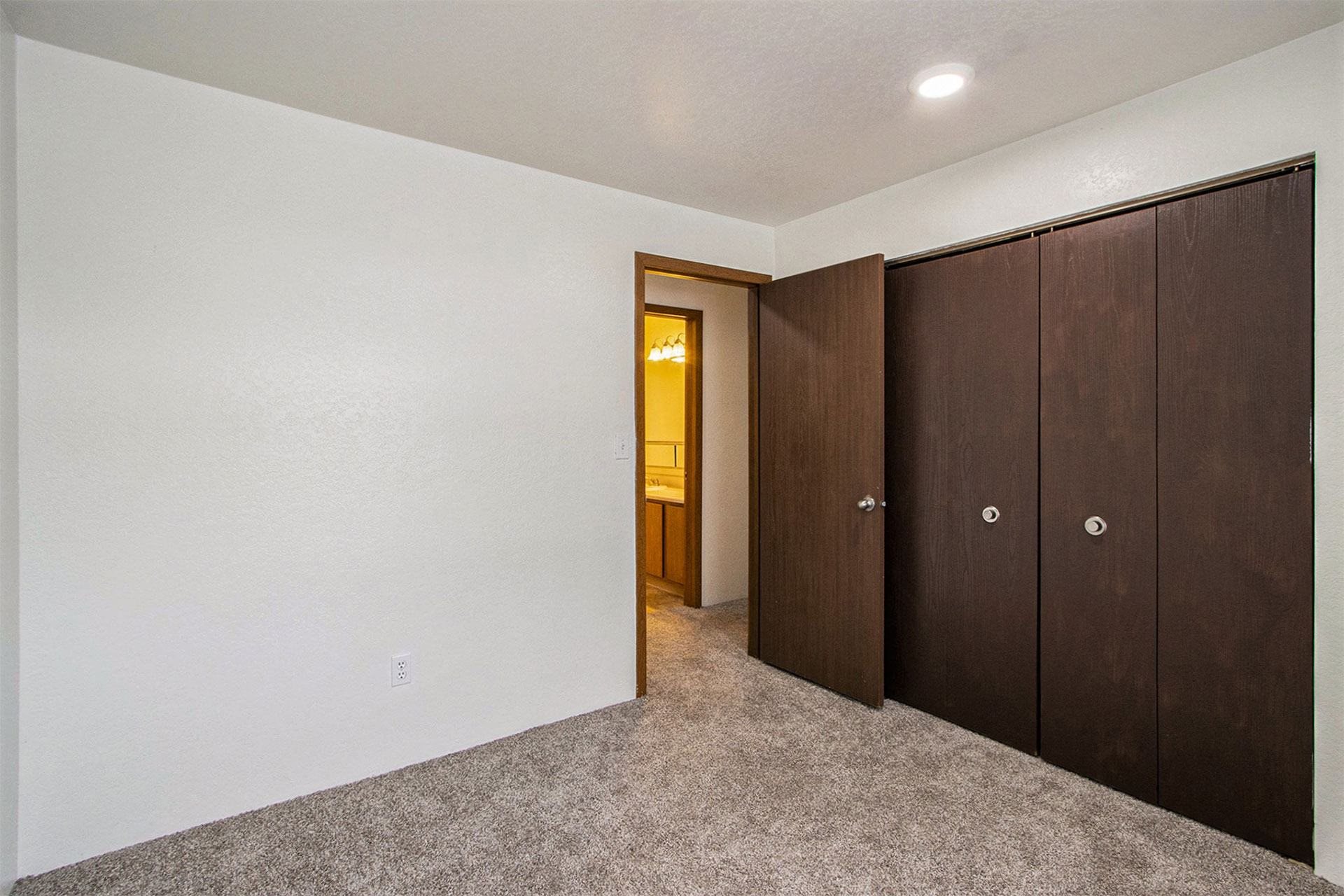 a bedroom with a closet and a door to a bathroom