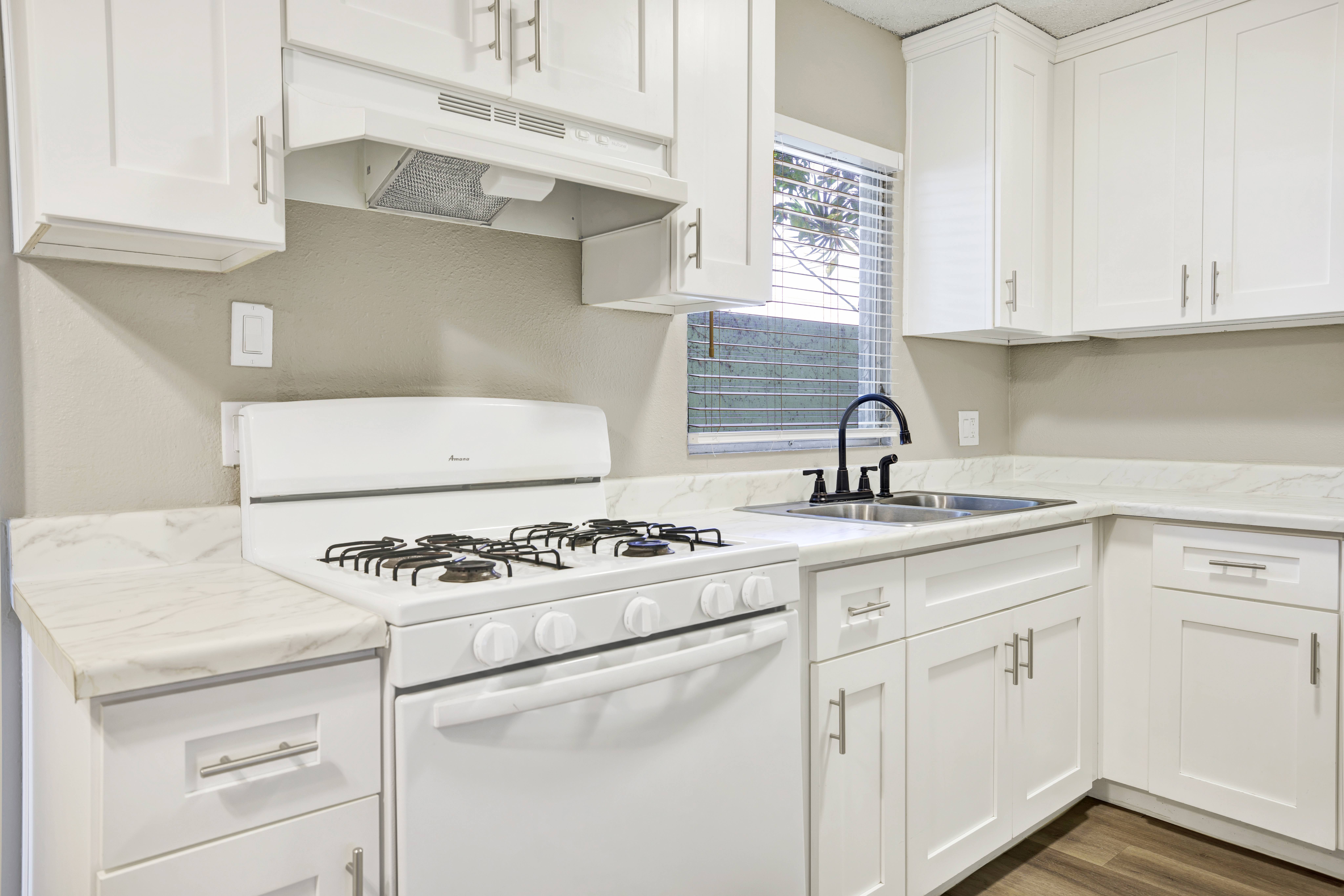 A white kitchen with a stove and oven.