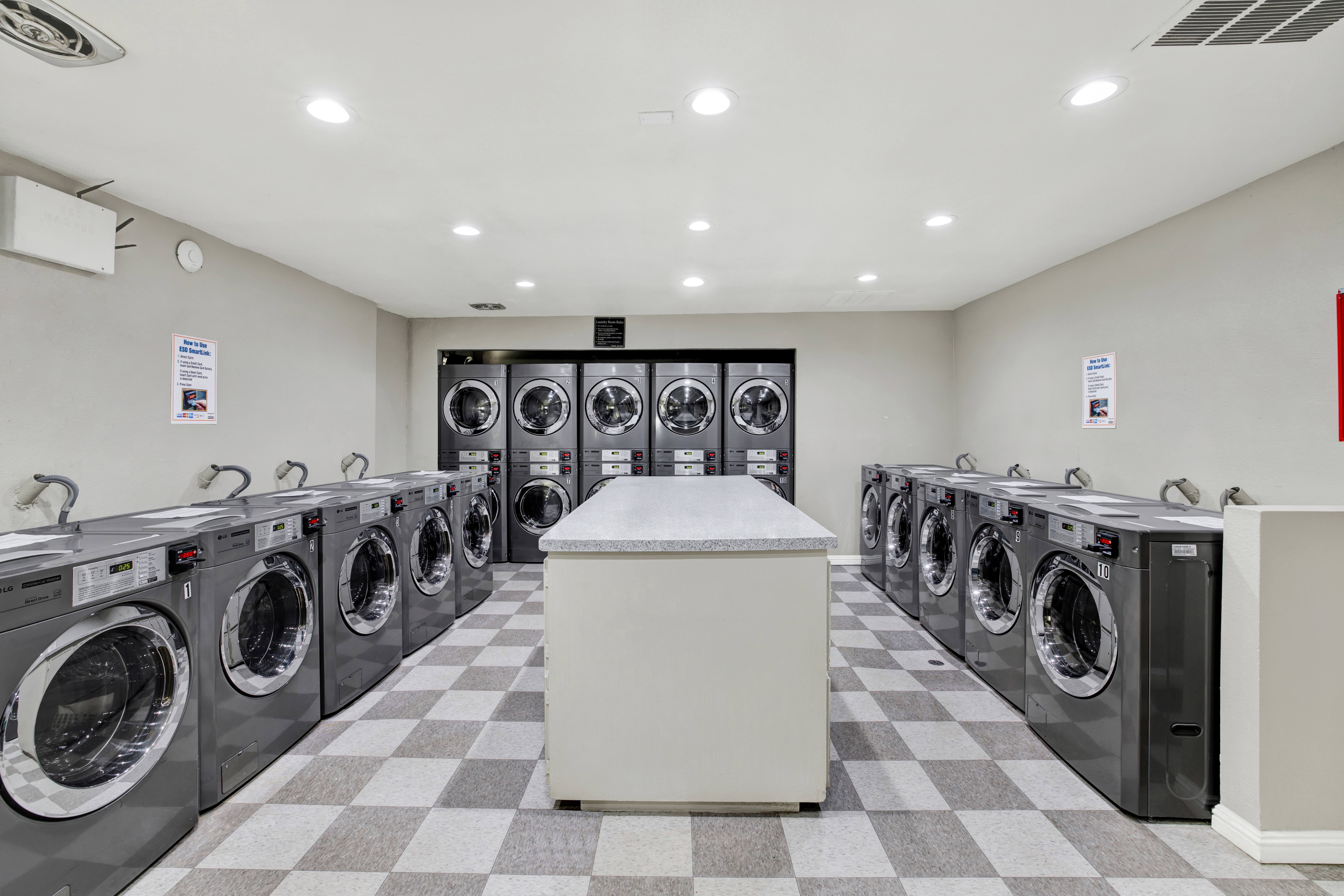A row of washing machines are lined up in a laundromat.