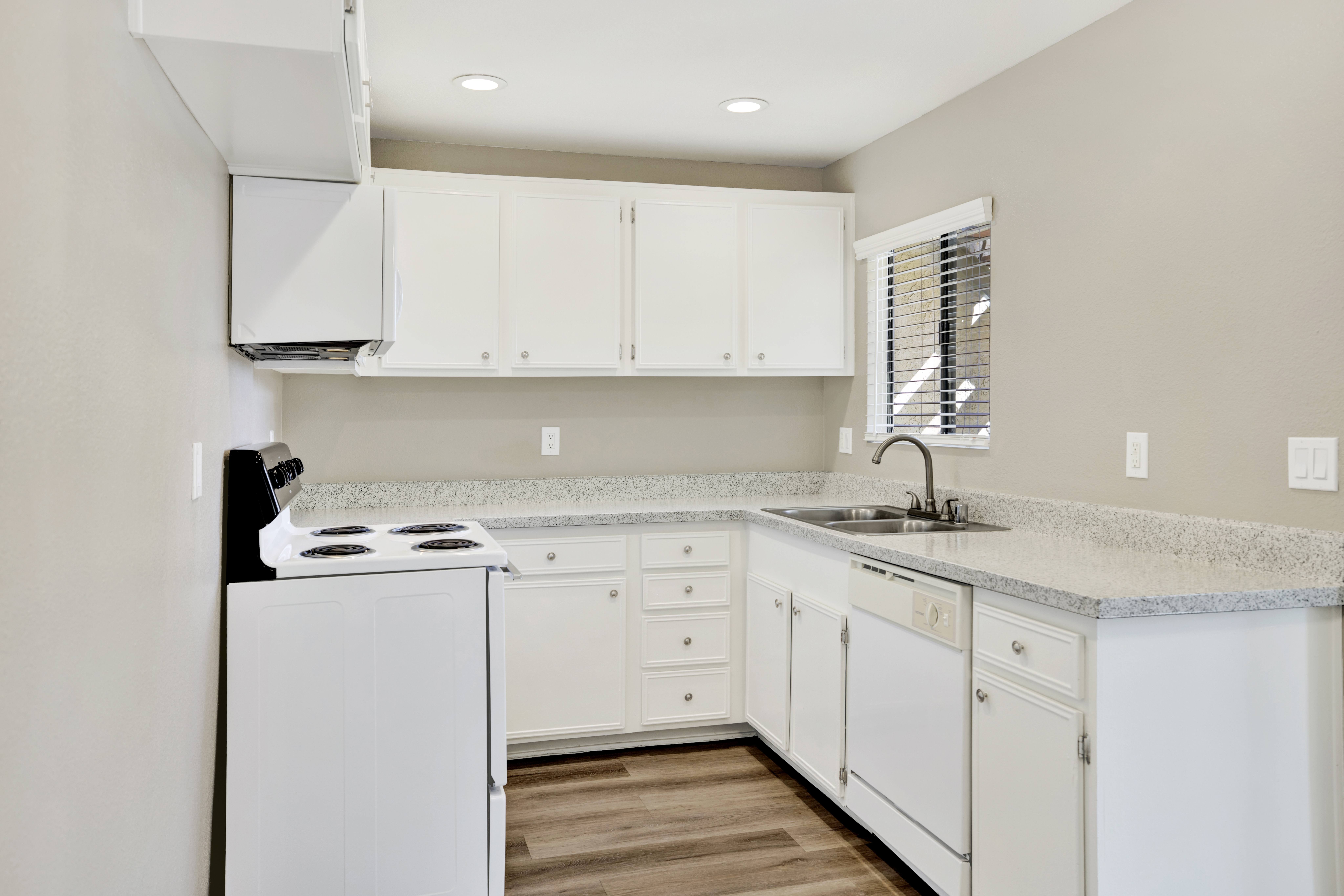 A kitchen with white appliances and cabinets.