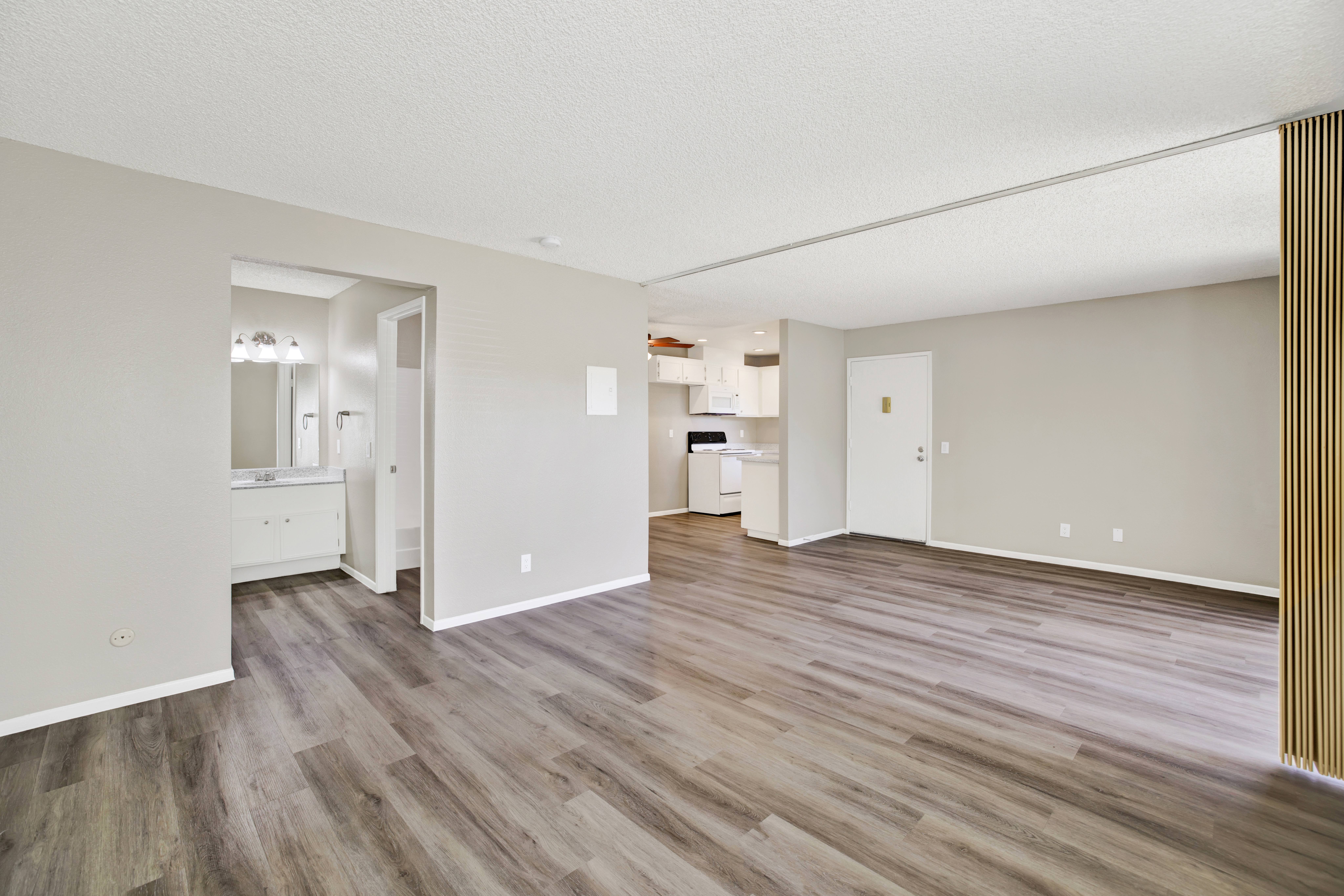 A room with wooden flooring and white walls.