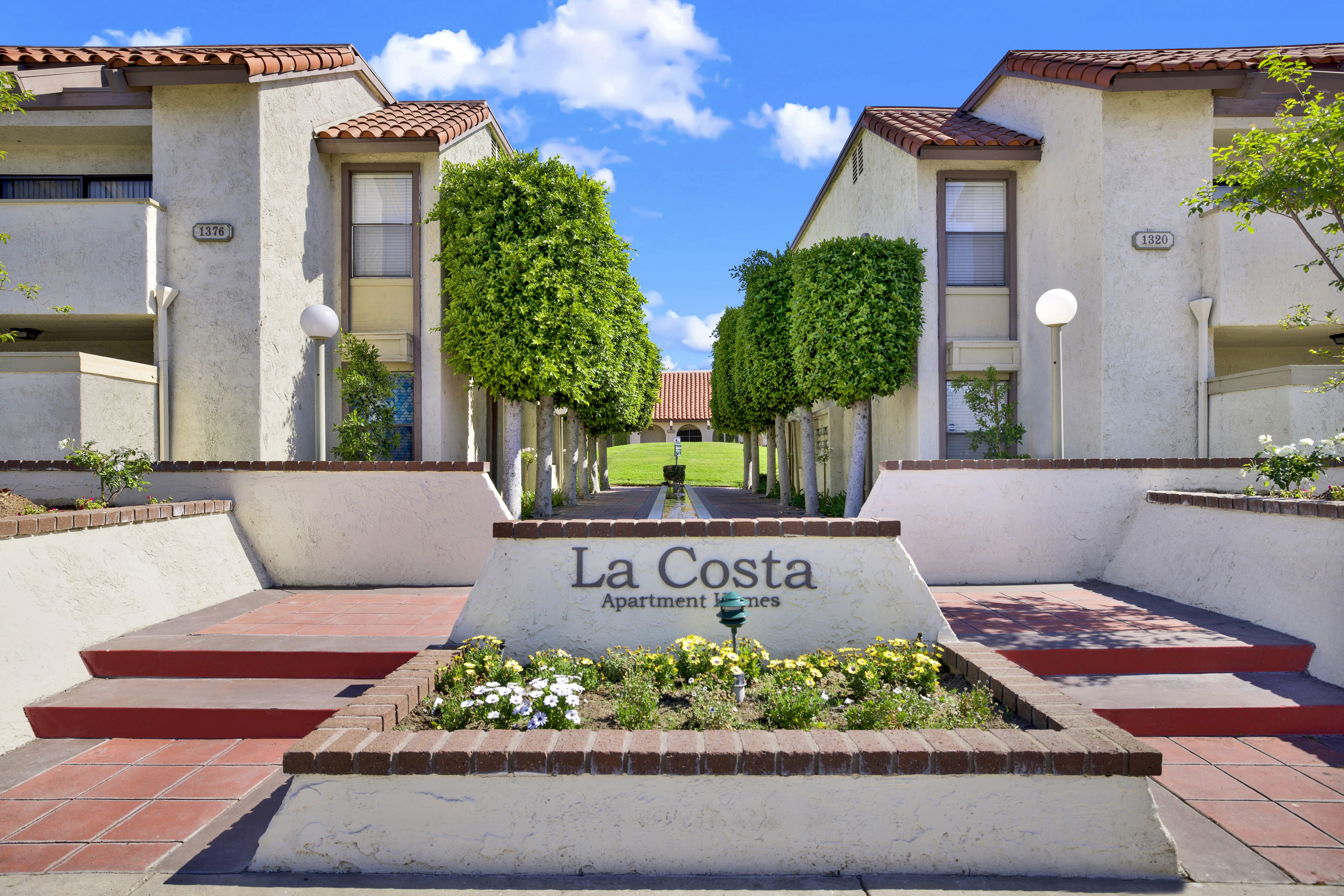 A sign that says La Costa Apartment in front of a building.