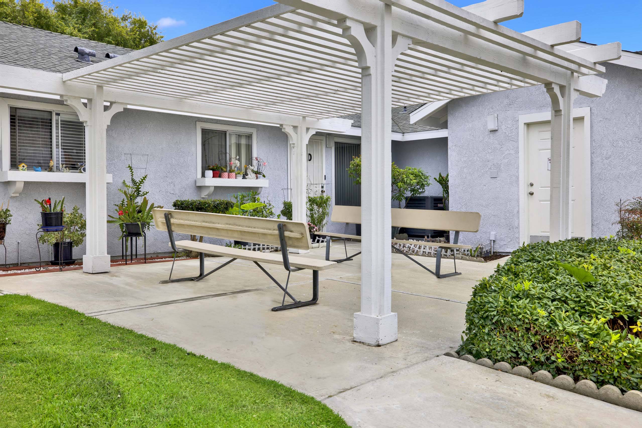 A white house with a covered patio area.
