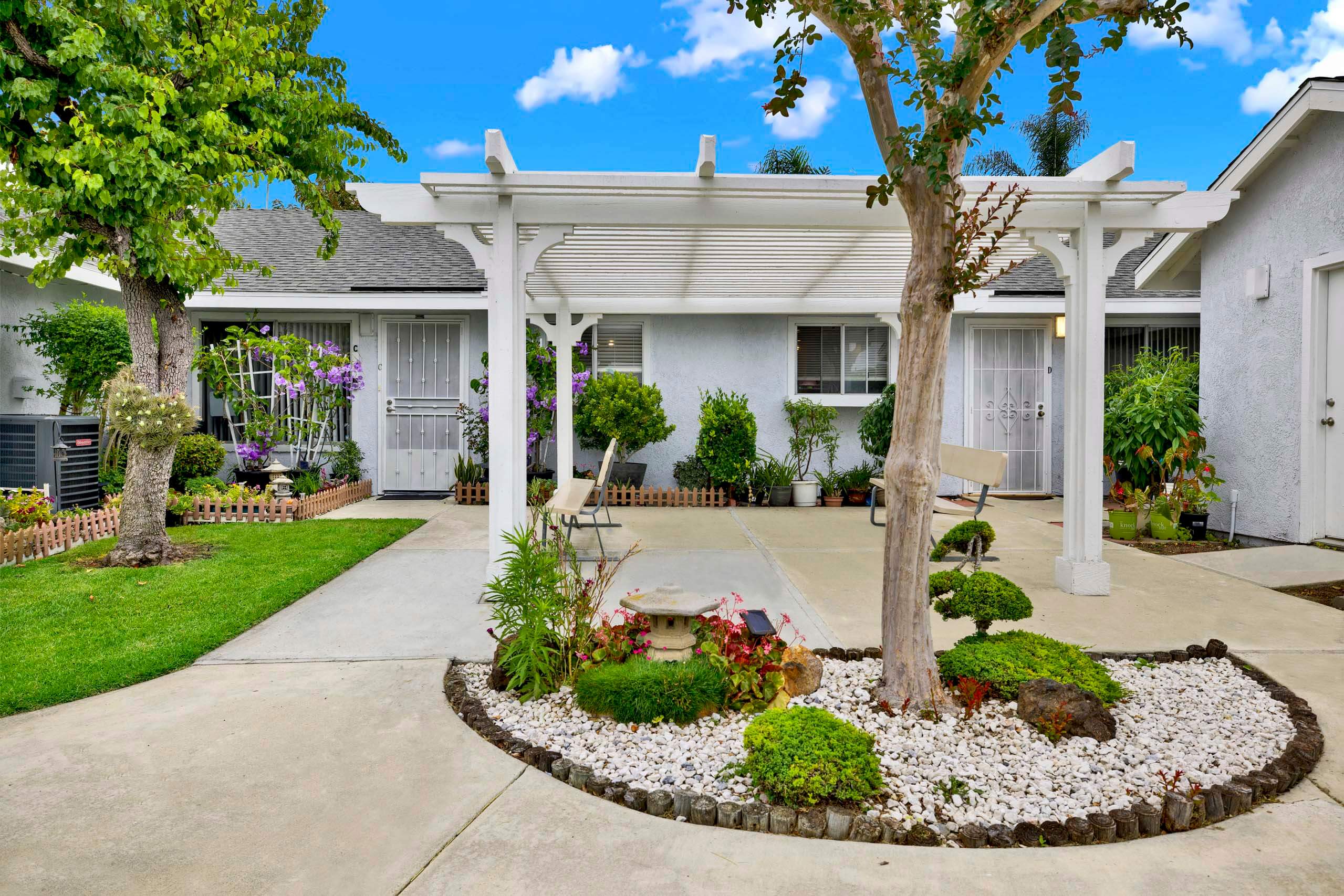 A white house with a landscaped front yard.