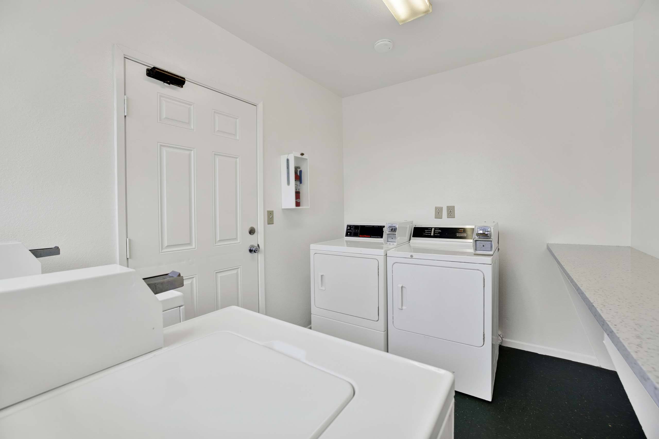 A white bathroom with a washing machine and dryer.