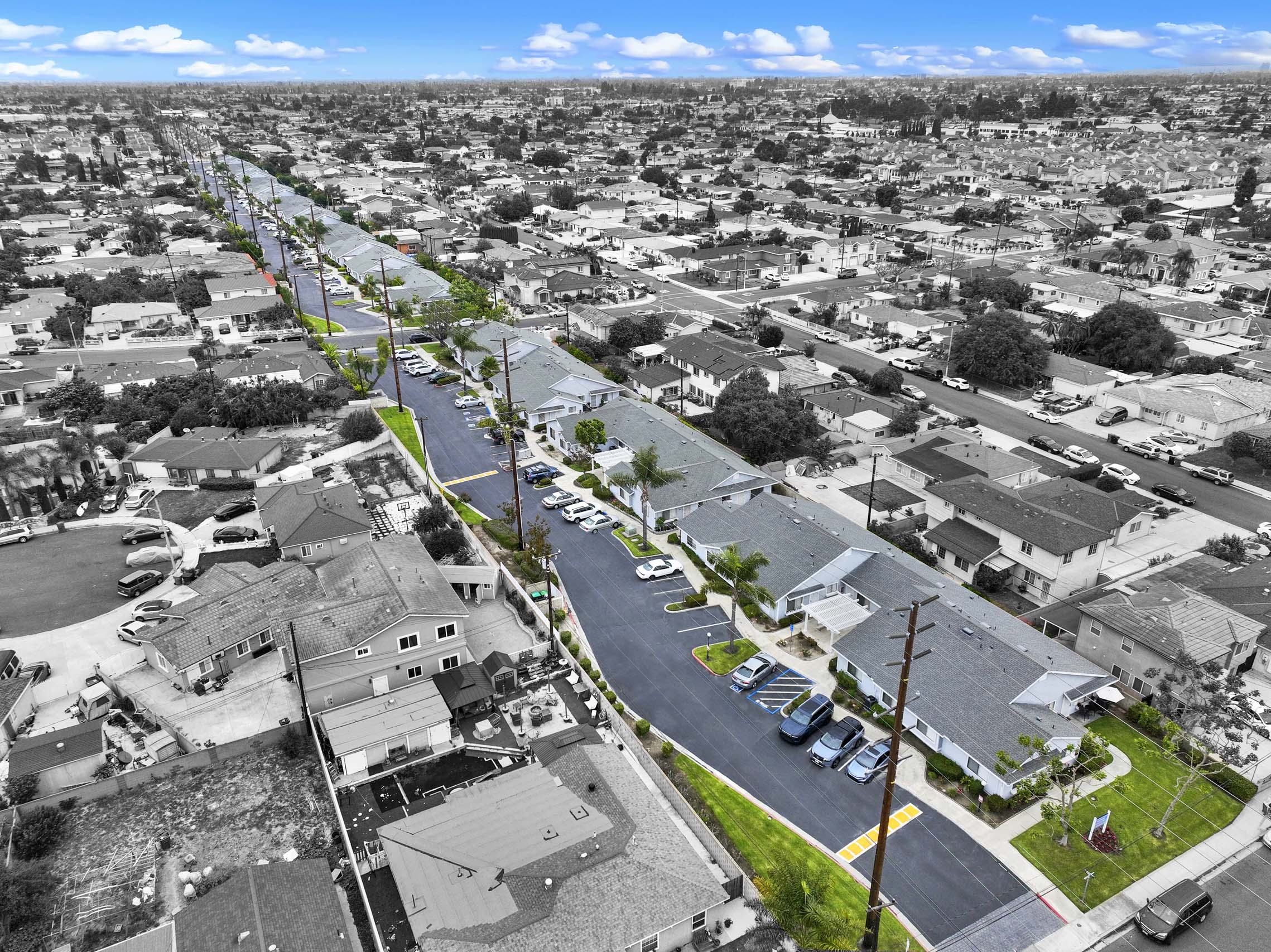 A long street with cars parked on the side.