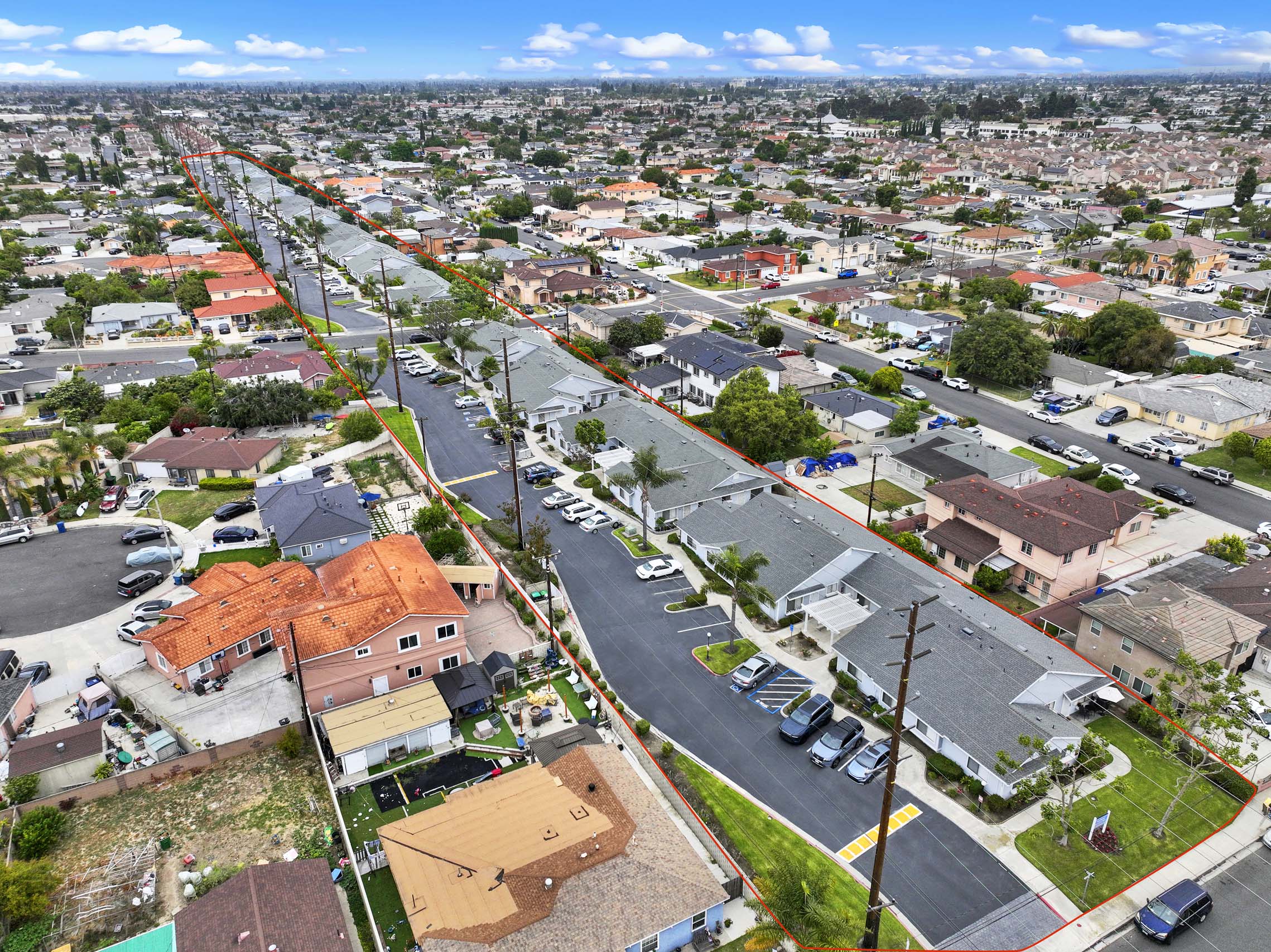 A long street with cars parked on the side.