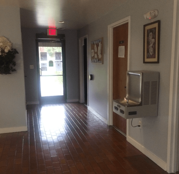 an empty hallway with a tv and a door to a hall way