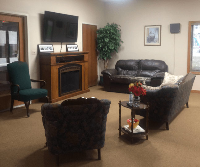 a living room with couches and a fireplace and a tv