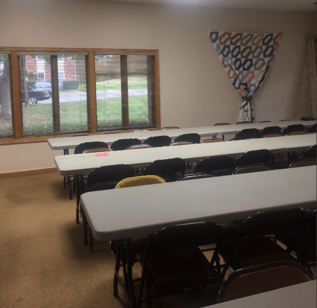 a group of tables and chairs in a classroom
