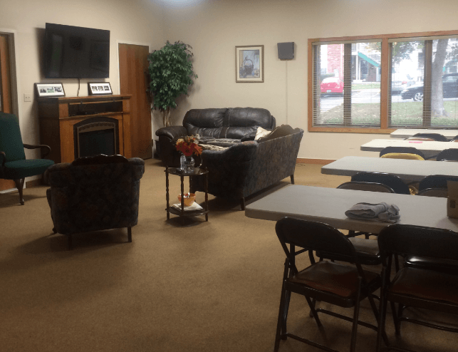 a living room with couches chairs and tables and a television