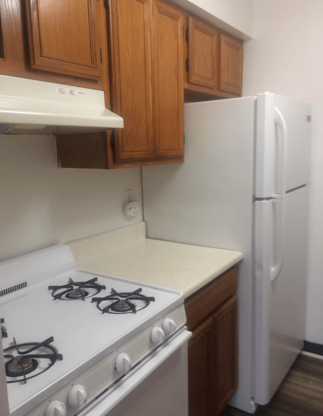 an empty kitchen with a stove and a refrigerator