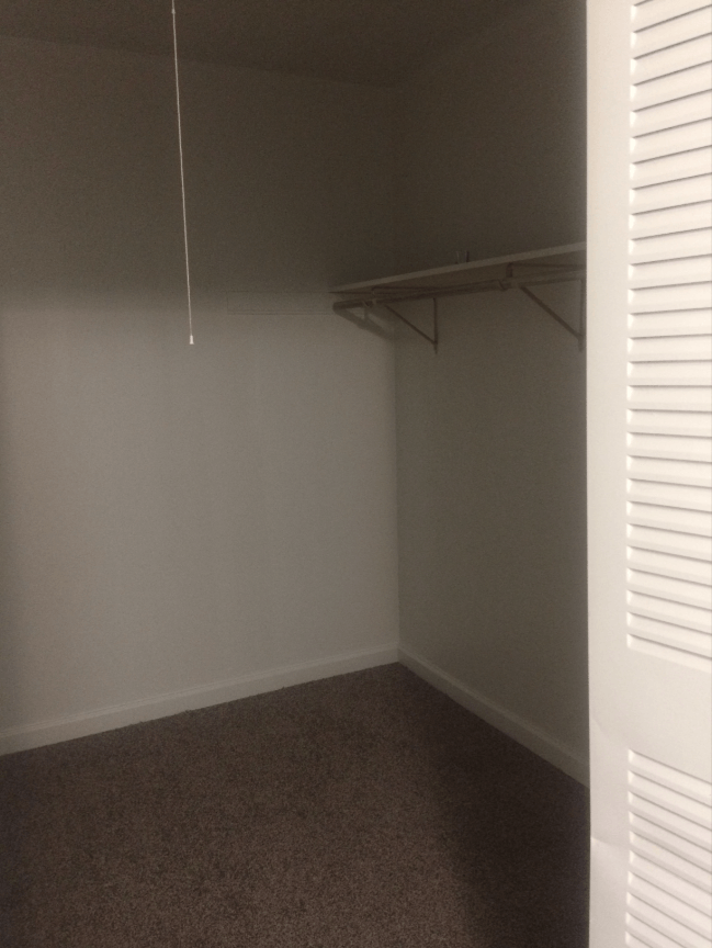 an empty closet in a room with white walls