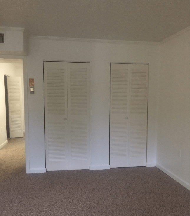 an empty room with two closet doors in it