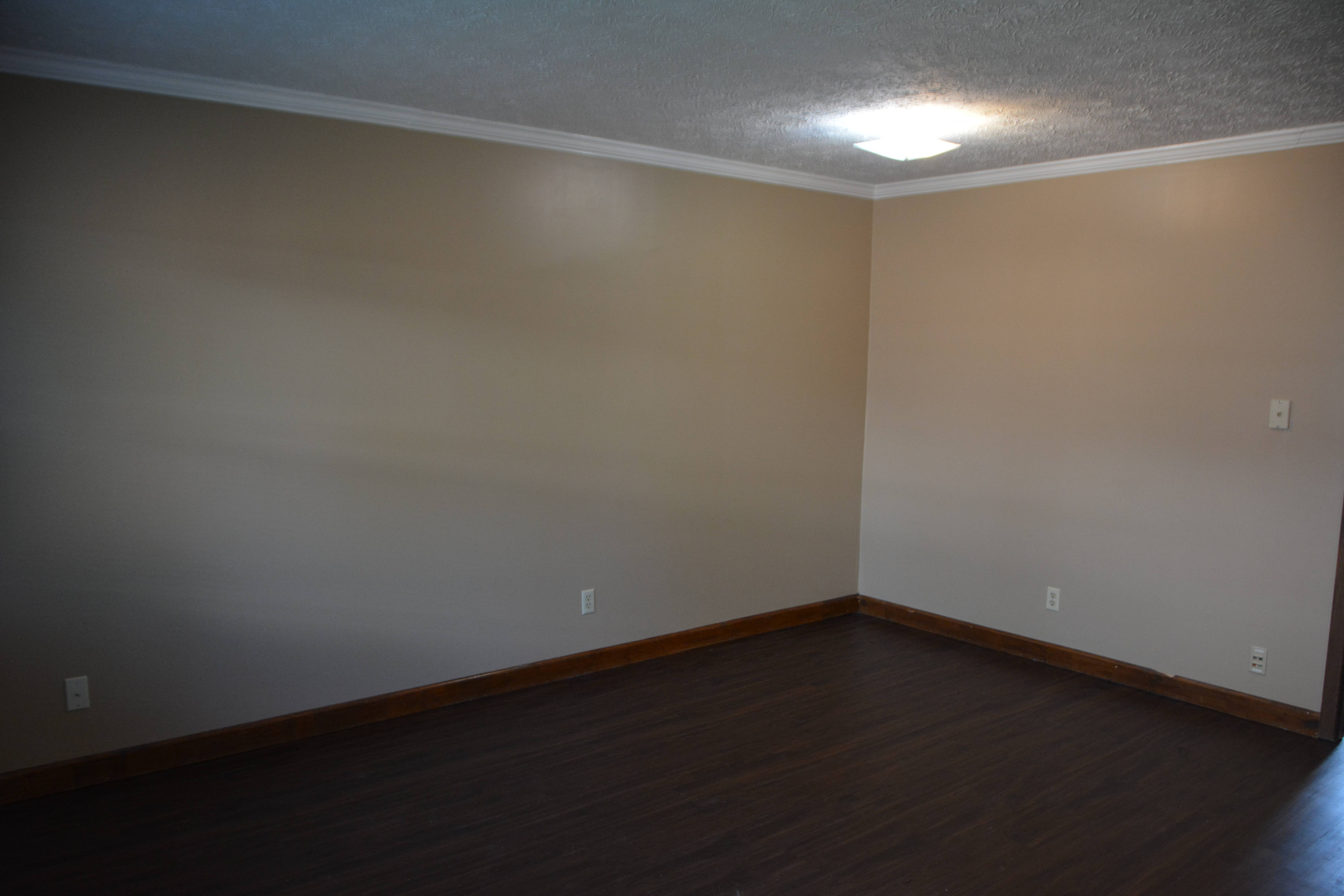 an empty room with wooden floors and a white ceiling and white walls